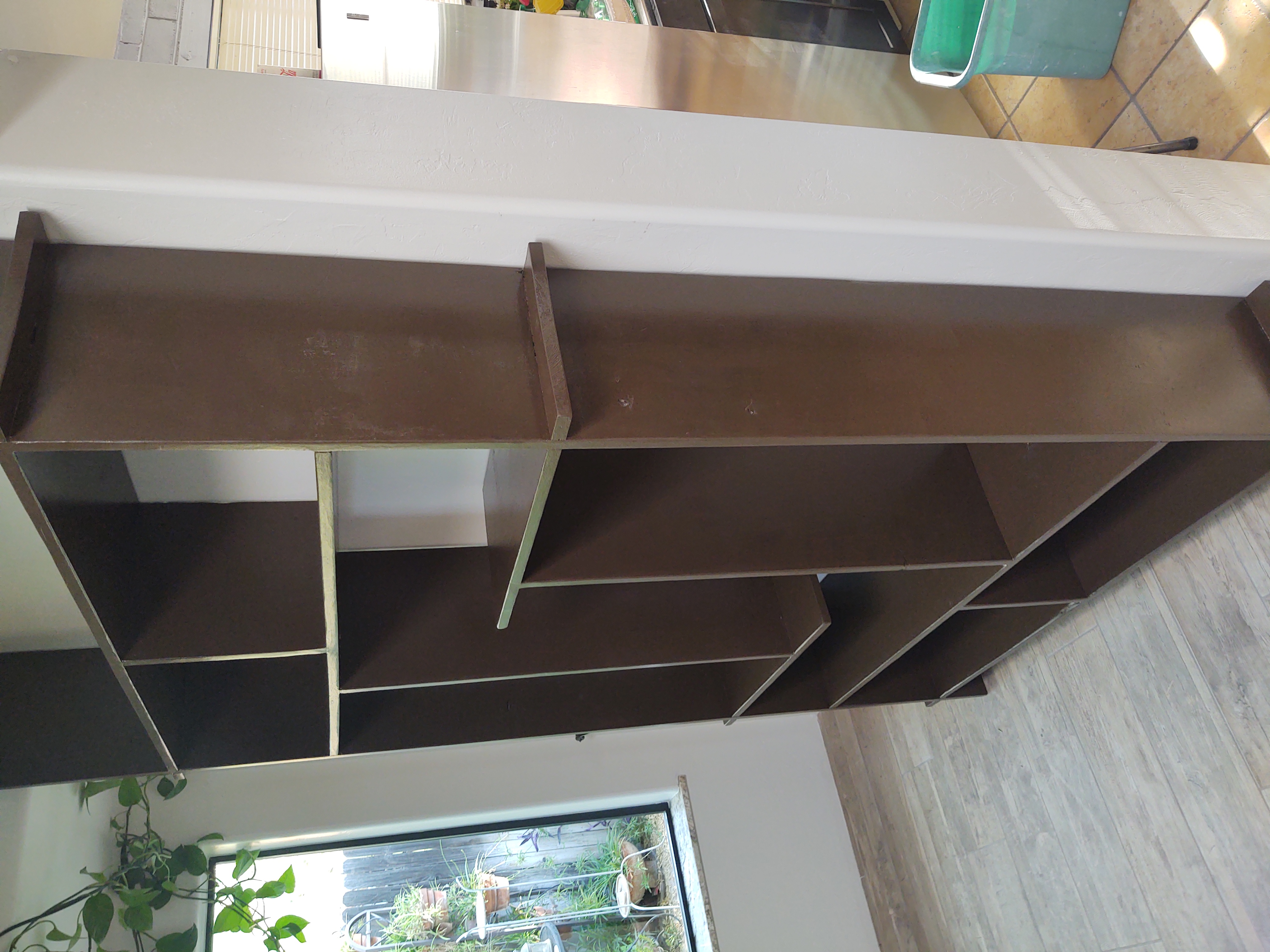 Finished dark-stained custom shelving unit installed